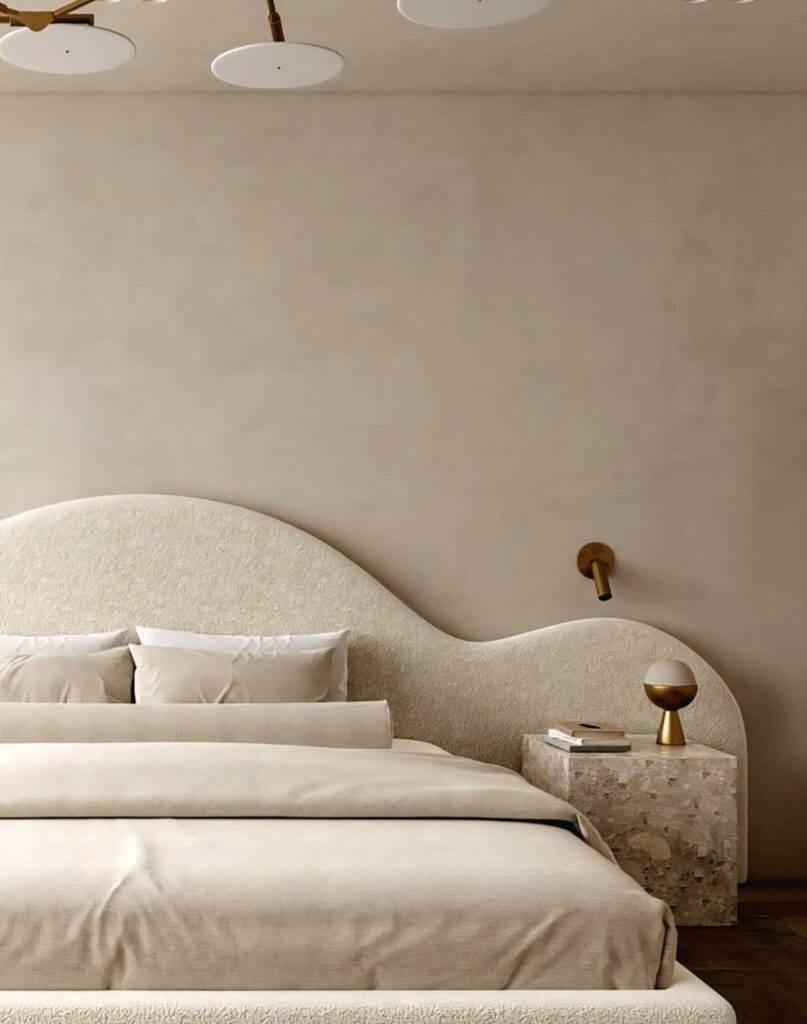 Organic-shaped cream headboard reflecting 2025 headboard design trends in a serene, minimalist bedroom.