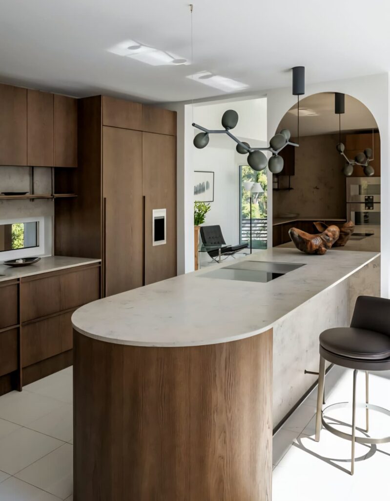 A sleek kitchen space with dark wood cabinets and a minimalist marble island, showcasing the harmony between wood grains and modern lines.